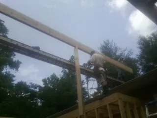 Carpenter setting a ridge beam over a new addition frame — Ice Dam Removal by Roofing Brothers in Teeds Grove