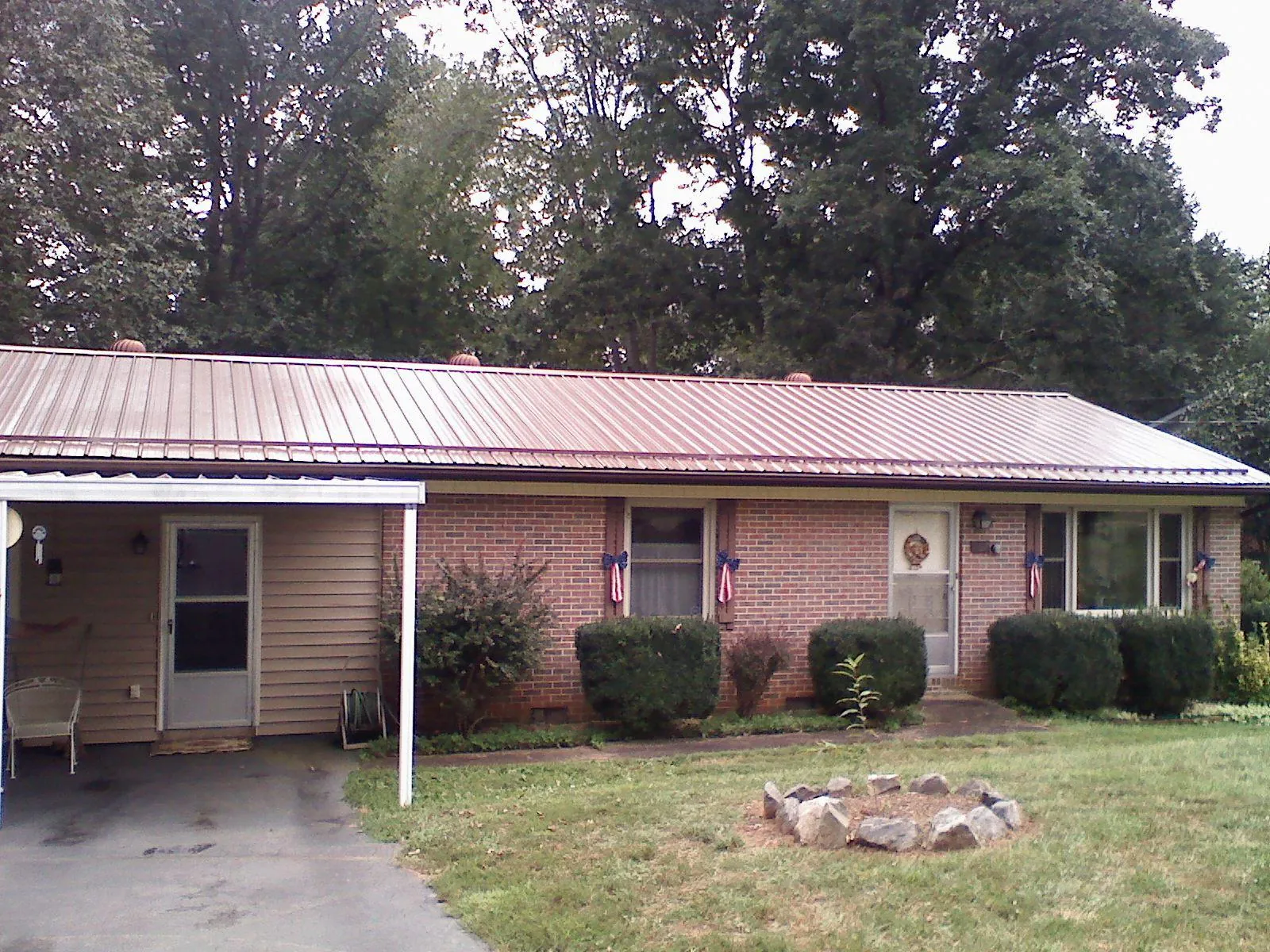 Bronze metal roof and carport on a brick ranch home — Roof Repair work by our crew in Teeds Grove